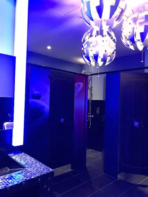 a bathroom with blue walls and a chandelier at Space Hotel @ Chinatown Kuala Lumpur in Kuala Lumpur