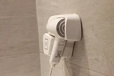 a hair dryer hanging on a wall in a bathroom at Hotel Maluri in Kuala Lumpur