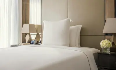 a bed with white sheets and pillows in a room at Four Seasons Hotel Kuala Lumpur in Kuala Lumpur