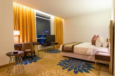a hotel room with a bed and a desk and a computer at Tamu Hotel & Suites Kuala Lumpur in Kuala Lumpur