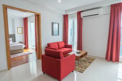 a living room with a red chair and a table at Tamu Hotel & Suites Kuala Lumpur in Kuala Lumpur