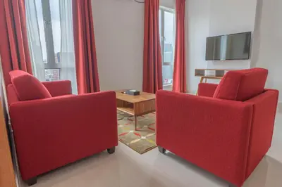 a living room with two red chairs and a table at Tamu Hotel & Suites Kuala Lumpur in Kuala Lumpur