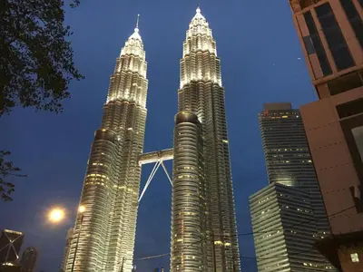 two tall skyscrapers in a city at night at Leo Backpackers @ Central Market in Kuala Lumpur
