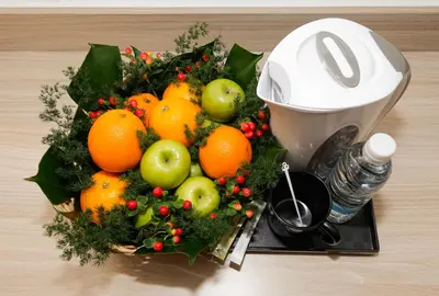 a bowl of fruit on a plate next to a juicer at My Hotel @ Bukit Bintang in Kuala Lumpur