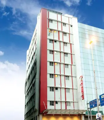 a tall red and white building with a blue sky at My Hotel @ Bukit Bintang in Kuala Lumpur
