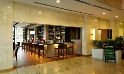 a bar in a restaurant with chairs and a counter at Holiday Heaven in Kuala Lumpur