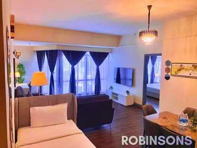 a living room with a couch and a tv in a room at Robinsons at Times Square Kuala Lumpur in Kuala Lumpur
