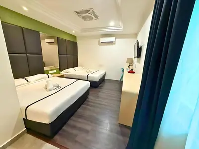a hotel room with two beds and a television at Seeds Hotel Ampang Point in Kuala Lumpur