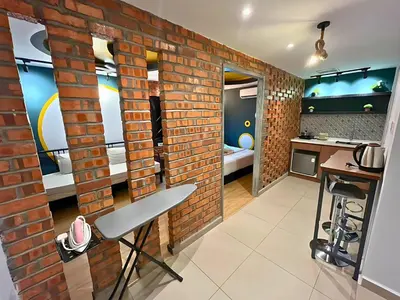 a room with a brick wall and a kitchen at Seeds Hotel Ampang Point in Kuala Lumpur