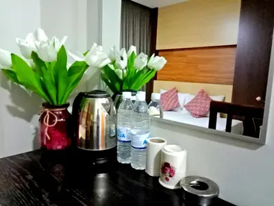 a table with bottles of water and white flowers at Eazy Hotel at Ampang in Batu Empat