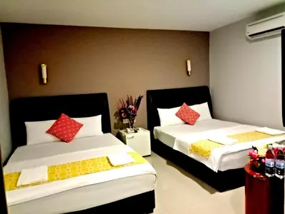 a bedroom with two beds with red and yellow pillows at Eazy Hotel at Ampang in Batu Empat