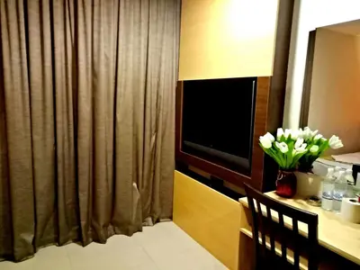 a hotel room with a desk with a vase of flowers at Eazy Hotel at Ampang in Batu Empat