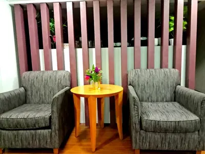 two chairs and a table with a vase of flowers at Eazy Hotel at Ampang in Batu Empat