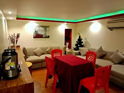 a living room with a couch and a table with red chairs at Eazy Hotel at Ampang in Batu Empat