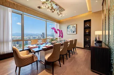 a dining room with a table and chairs and a large window at Banyan Tree Kuala Lumpur in Kuala Lumpur