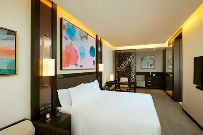 a bedroom with a large white bed and a television at Banyan Tree Kuala Lumpur in Kuala Lumpur