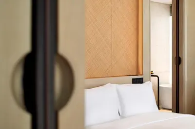 a bed with white pillows in a room at The RuMa Hotel and Residences in Kuala Lumpur