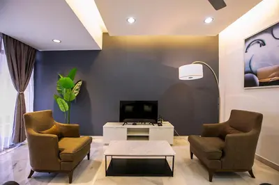 a living room with two chairs and a tv at The Forum Condominium by LaFabrica in Kuala Lumpur