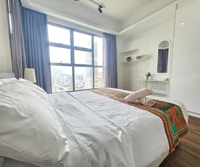 a large white bed in a room with a large window at Holiday Paradise in Kuala Lumpur