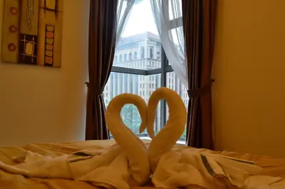 two towels forming the shape of hearts on a bed with a window at Holiday Paradise in Kuala Lumpur