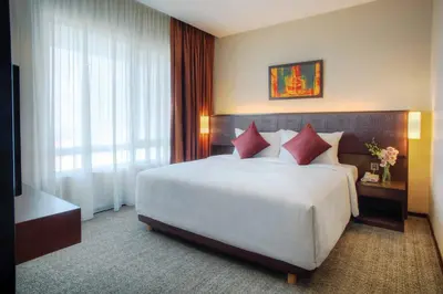 a bedroom with a large white bed with red pillows at Furama Bukit Bintang, Kuala Lumpur in Kuala Lumpur