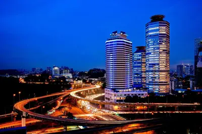 a city skyline with two tall skyscrapers at night at Wyndham Grand Bangsar Kuala Lumpur in Kuala Lumpur