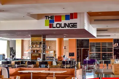 a restaurant with tables and chairs and a library at Wyndham Grand Bangsar Kuala Lumpur in Kuala Lumpur