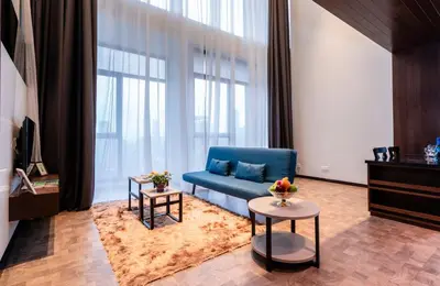 a living room with a blue couch and a large window at Expressionz Professional Suites by MyKey in Kuala Lumpur