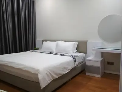 a bedroom with a bed with white sheets and a mirror at Soho Suites KLCC by Elite in Kuala Lumpur