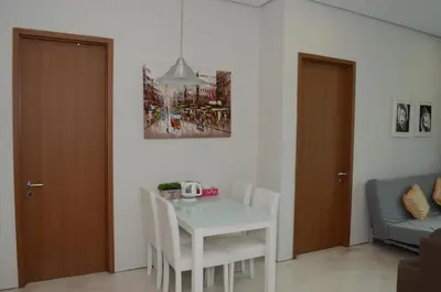 a dining room with a white table and a couch at Soho Suites KLCC by Elite in Kuala Lumpur