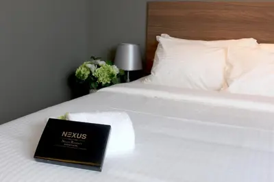 a book sitting on top of a white bed at Imperial Regency Suites & Kuala Lumpur in Kuala Lumpur
