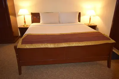 a large bed in a hotel room with two lamps at Grand Service Apartment @ Times Square in Kuala Lumpur