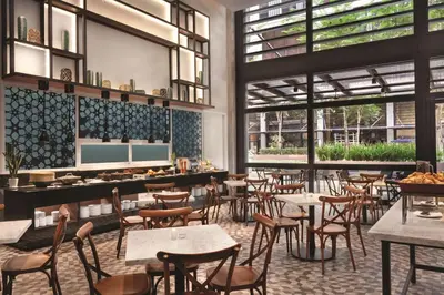 a restaurant with tables and chairs and windows at Hyatt House Kuala Lumpur, Mont Kiara in Kuala Lumpur