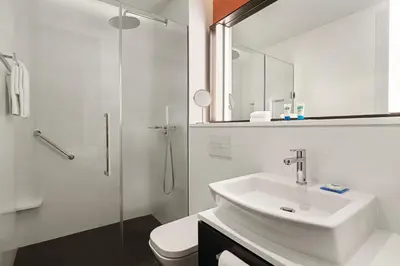 a white bathroom with a sink and a shower at Hyatt House Kuala Lumpur, Mont Kiara in Kuala Lumpur
