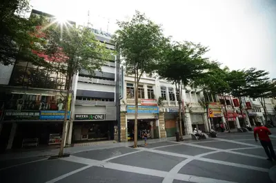 an empty city street with trees and buildings at Hotel A-One in Kuala Lumpur