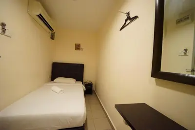 a small room with two beds and a mirror at Hotel A-One in Kuala Lumpur