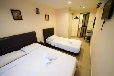 a hotel room with two beds and a television at Hotel A-One in Kuala Lumpur