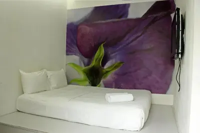 a room with a white bed with a purple flower at V Garden Hotel in Kuala Lumpur