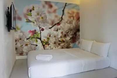 a bed in a room with a flower painting on the wall at V Garden Hotel in Kuala Lumpur
