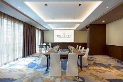a conference room with a long table and white chairs at Dorsett Hartamas Kuala Lumpur in Kuala Lumpur