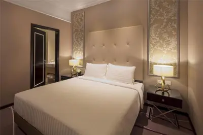 a bedroom with a large white bed with two lamps at Dorsett Hartamas Kuala Lumpur in Kuala Lumpur