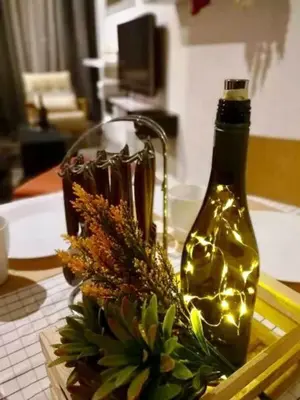 a bottle of wine sitting on a table with lights at Charming Bedroom - next to train station at Est Bangsar in Kuala Lumpur