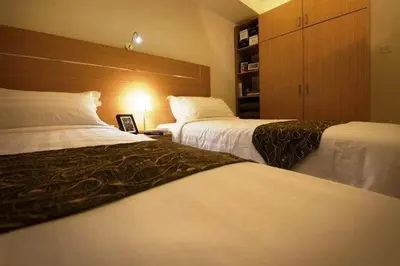 a hotel room with two beds and a closet at One-Stop Residence & Hotel in Kuala Lumpur