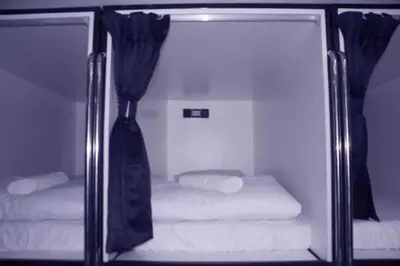 a glass room with two beds and a curtain at OYO 91036 J CAPSULE HOTEL @ JALAN BUKIT BINTANG in Kuala Lumpur
