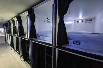 a row of bunk beds in a room with curtains at OYO 91036 J CAPSULE HOTEL @ JALAN BUKIT BINTANG in Kuala Lumpur