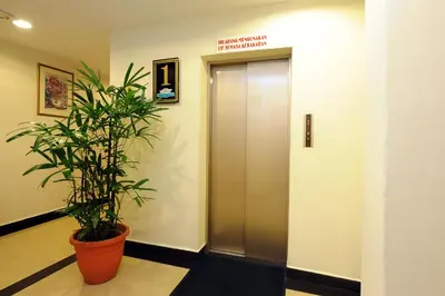 an elevator in a building with a potted plant at Palm Inn Ampang Point in Ampang