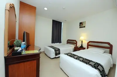 a hotel room with two beds and a desk and a television at Palm Inn Ampang Point in Ampang