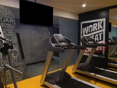 a gym with two exercise bikes and a tv at ibis Styles Kuala Lumpur Bukit Bintang in Kuala Lumpur