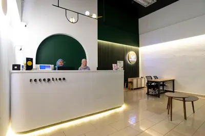 two people sitting at a reception desk in a store at SG Residence Kuala Lumpur in Kuala Lumpur