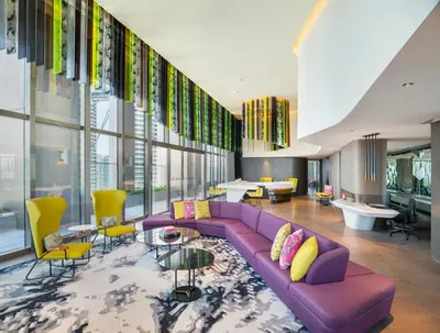 a living room with a purple couch and yellow chairs at W Kuala Lumpur in Kuala Lumpur